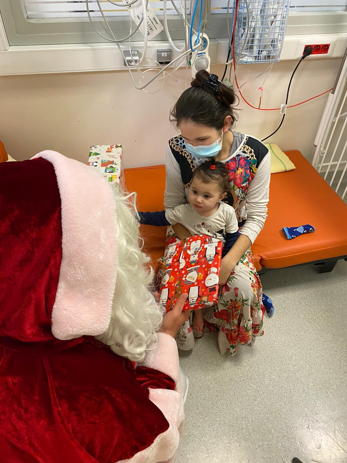 Le père Noël offre un cadeau à un enfant malade