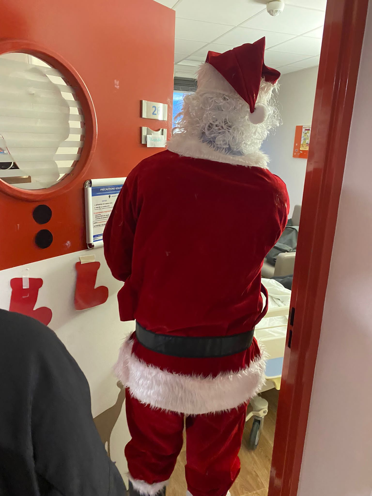Le père Noël entrant dans une chambre d'enfant à l'hôpital Robert Debré