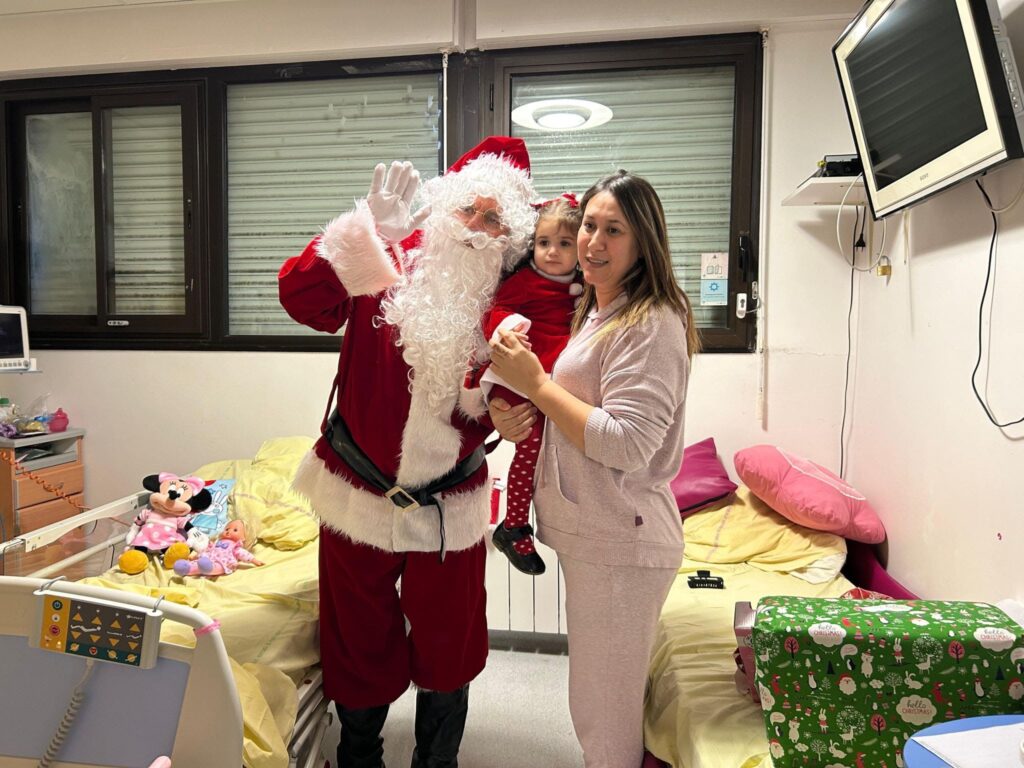 Le Père Noël donne des cadeaux à un enfant hospitalisé