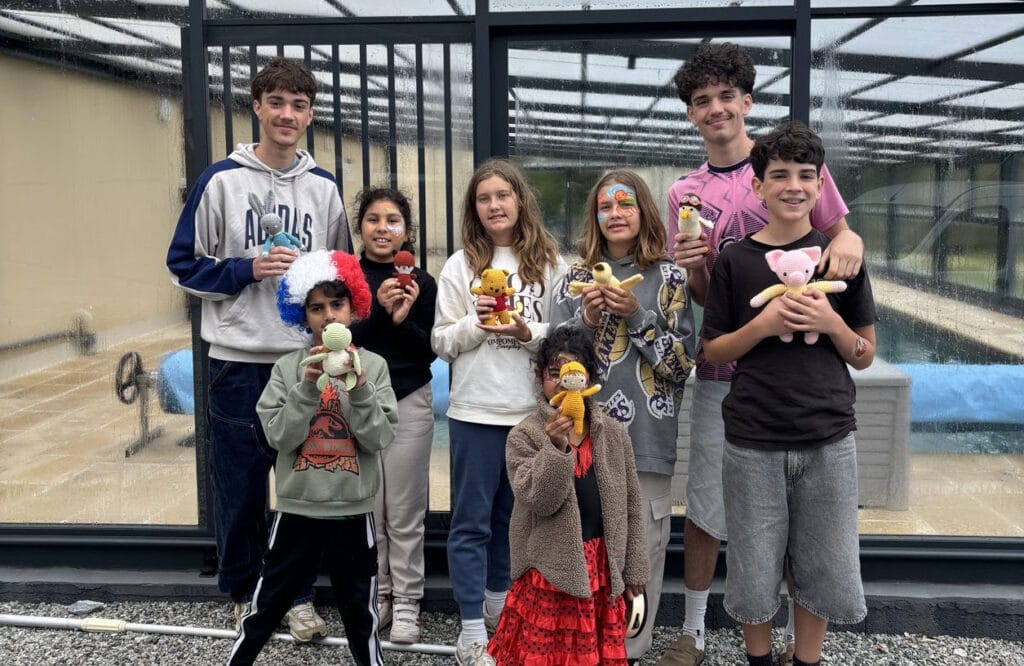 Les enfants des familles LHF devant la piscine posant avec leur doudou en crochet